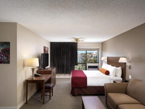 a hotel room with a bed and a window at Huntingdon Hotel and Suites in Victoria