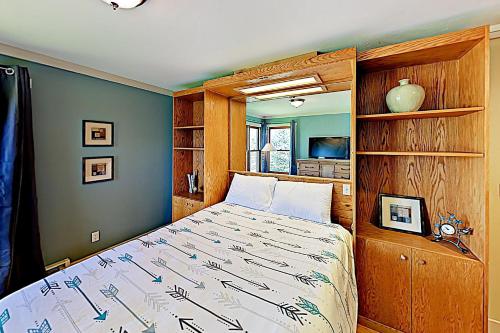 Schlafzimmer mit einem Bett mit einem Kopfteil aus Holz in der Unterkunft Sunburst 21B in Steamboat Springs