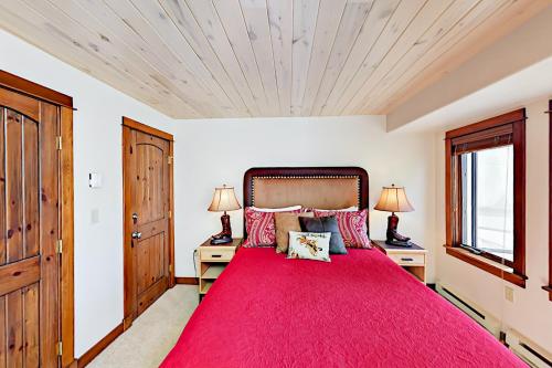 een slaapkamer met een groot bed en een rode deken bij Storm Watch 103 in Steamboat Springs