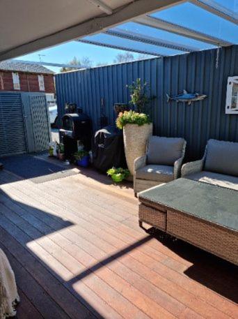 a patio with two chairs and a table on a deck at BnB on Carvell in Blenheim