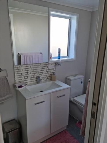 a white bathroom with a sink and a toilet at BnB on Carvell in Blenheim
