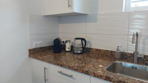 un bancone della cucina con lavandino e un apparecchio sopra di Kas Trupial a Willemstad