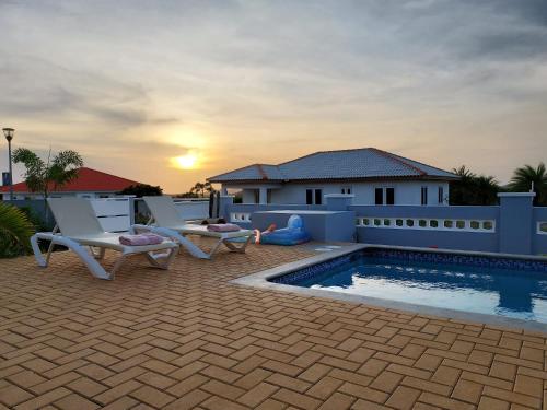 a patio with two chairs and a swimming pool at Kas Trupial in Willemstad