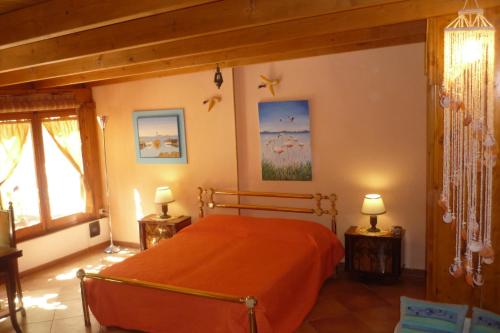 a bedroom with an orange bed and two lamps at B&B Marino E Lily in Baratili San Pietro