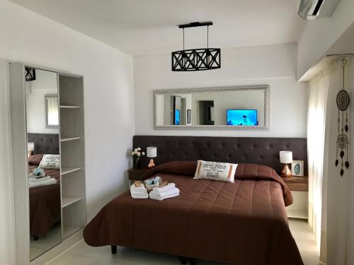 un dormitorio con una cama y un espejo en 1353 Amplió y luminoso, en Mar del Plata