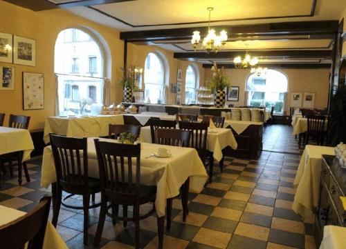 um restaurante com mesas e cadeiras com toalha de mesa branca em Der Fürstenhof em Kempten