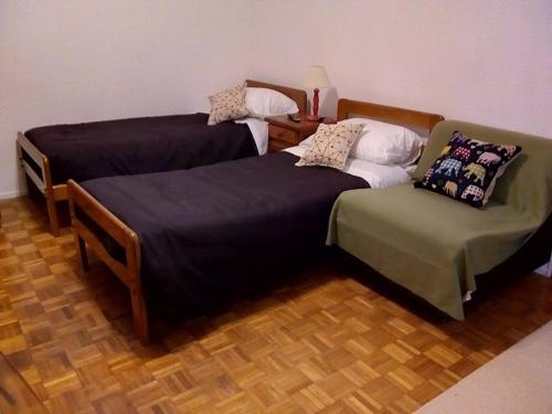 - deux lits et une chaise dans une chambre dans l'établissement Cortina, à Buenos Aires