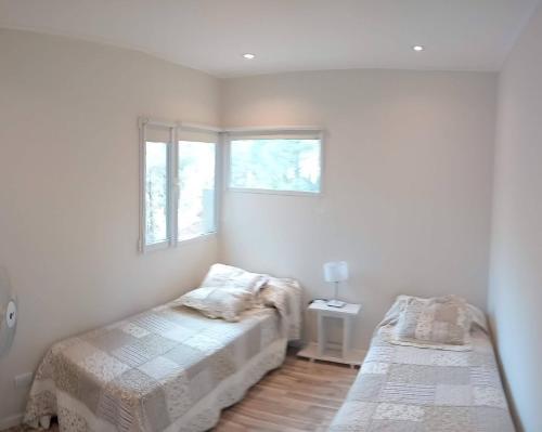 Un dormitorio con dos camas y una ventana en Balcón del Bosque, en Monte Hermoso