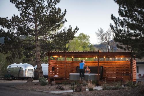 a woman standing in a small wooden cabin with a man at Amigo Motor Lodge in Salida