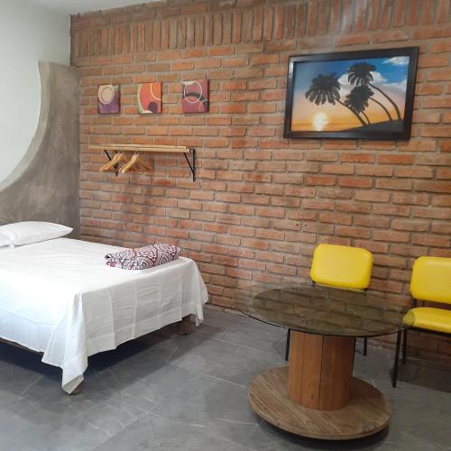 a room with a bed and a table and a brick wall at Loft con jardín 1 in Puerto Vallarta