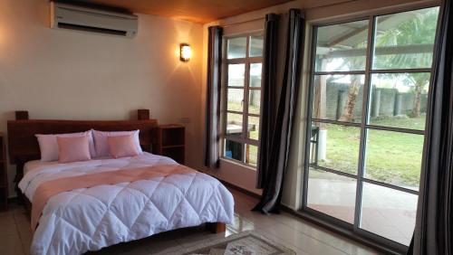 ein Schlafzimmer mit einem Bett und einem großen Fenster in der Unterkunft Senari Bay Resort in Pantai Cenang