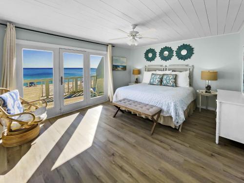 a bedroom with a bed and a balcony with the ocean at On the Beach Townhouse in Inlet Beach