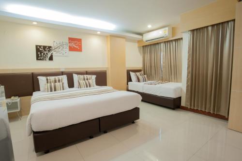 Tempat tidur dalam kamar di Taragrand Donmuang Airport Hotel