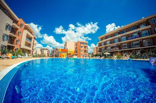 a large swimming pool in front of some buildings at Waterpark Fort Apartments in Sunny Beach