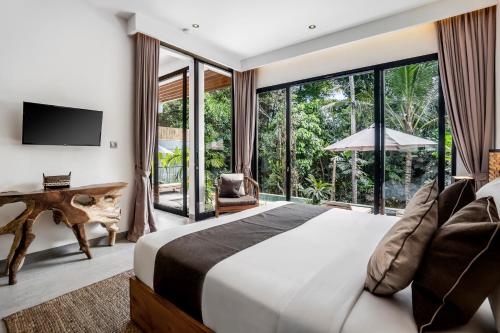 a bedroom with a large bed and a large window at Villa Oiseau Paradis in Ubud