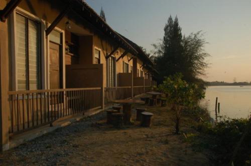 ein Gebäude mit einem Picknicktisch neben einem See in der Unterkunft Cerana Villa Eco Resort in Kota Bharu