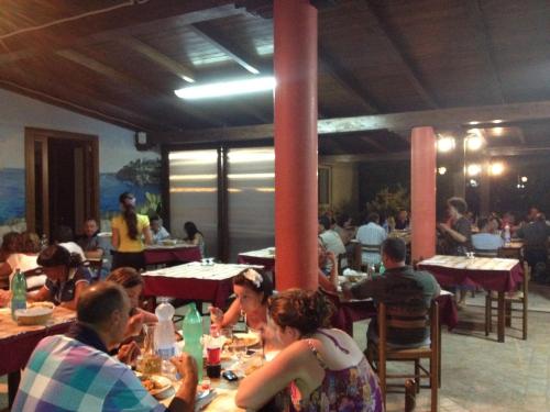 a group of people sitting at tables in a restaurant at La Carcara in Otranto