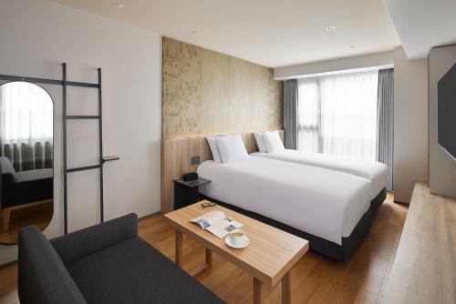 a hotel room with a bed and a table and a couch at Oakwood Hotel Oike Kyoto in Kyoto