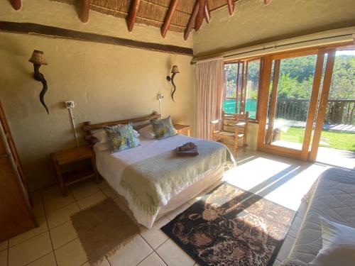 - une chambre avec un lit et une grande fenêtre dans l'établissement Outspan Safaris, à Komga
