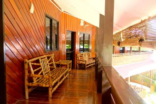 a room with two chairs on a wooden wall at Keyun's Inn- Across Cloud 9 in General Luna