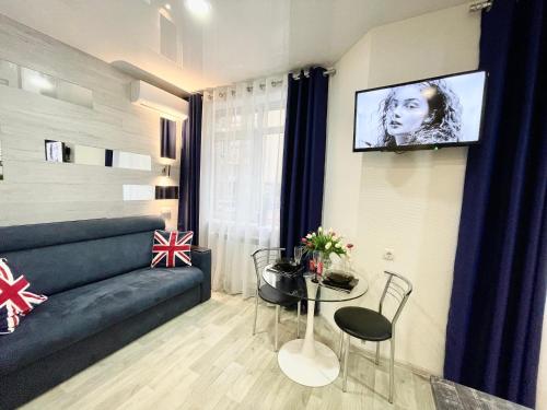 ein Wohnzimmer mit einem Sofa und einem TV an der Wand in der Unterkunft Apartment Studio London 51 in Irpin