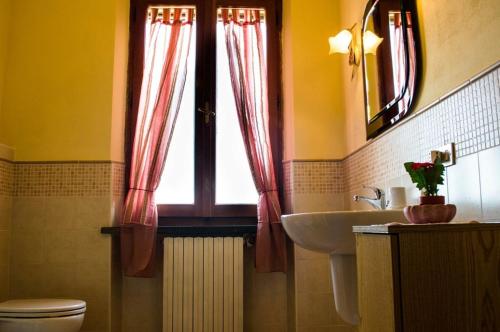 La salle de bains est pourvue de toilettes, d'un lavabo et d'une fenêtre. dans l'établissement Casa Ricciardi, à Chianni