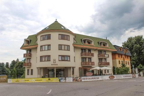 a large white building with a green roof at MyMara, Apartmán Beťo in Bešeňová