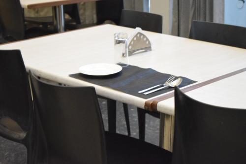 a table with a plate and a fork and knife at Hotel The Nook in Madurai