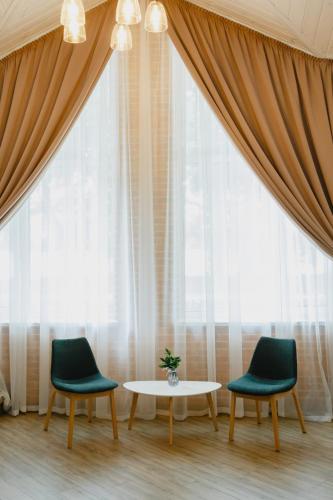 two chairs and a table in front of a window at Nicolas Resort Club in Kyiv