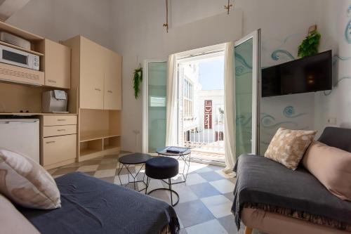 a living room with a couch and a kitchen at La Casa de la Favorita in Tarifa