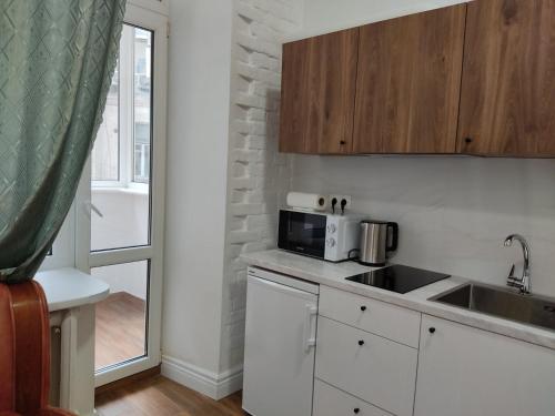 cocina con fregadero y microondas en N.A.N. Apartments City Centre en Kiev