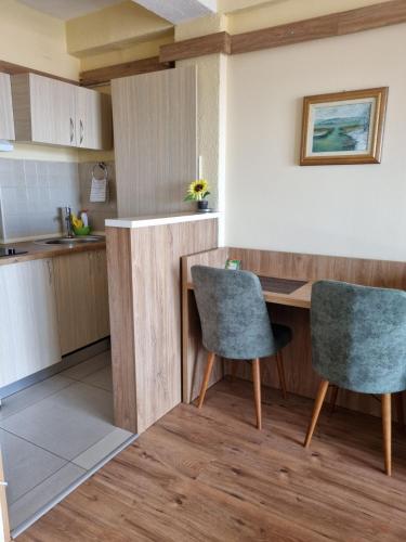 a kitchen with a wooden table and two chairs at Lukanov Apartments & Guest Rooms in Ohrid