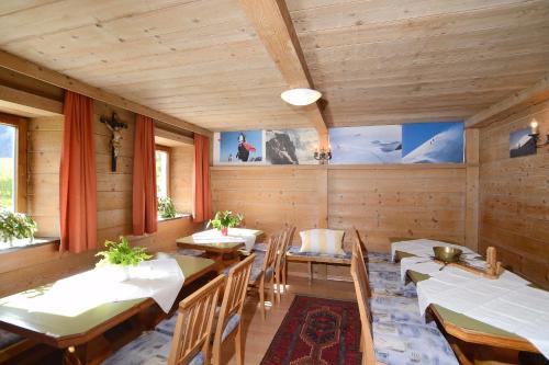 a dining room with tables and chairs and windows at FERIENHAUS BERGBLICK 10-25 PERS Urig, echt & perfekt für Familien und Freunde Ideal für unvergessliche Tage mit traumhaftem Bergpanorama in Längenfeld