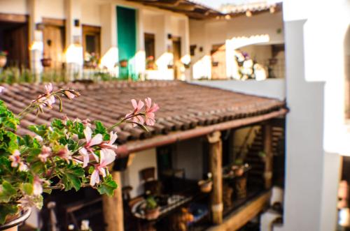 a plant with pink flowers sitting on top of a building at Hotel La Casona in Tapalpa