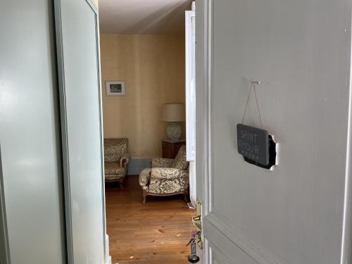an open door to a living room with a chair at Chateau de Breuil en Beaujolais in Salles-Arbuissonnas