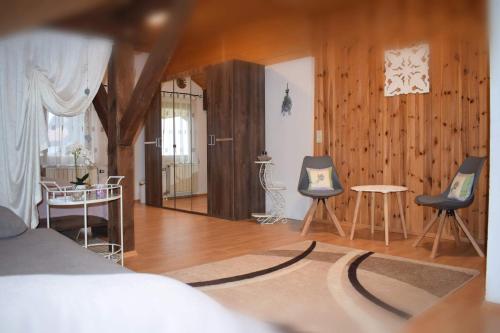 1 dormitorio con 1 cama, 2 sillas y mesa en Edelstein Ferienwohnung Philippsreut en Philippsreut