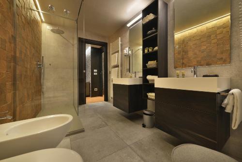 a bathroom with a sink and a toilet and a tub at Hotel Compagnoni in Livigno