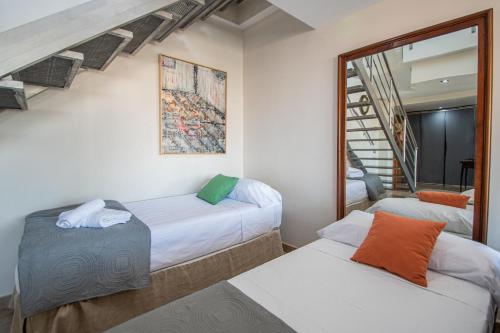 Zimmer mit 2 Betten und einer Treppe in der Unterkunft Loft Space - Time in Cádiz in Cádiz