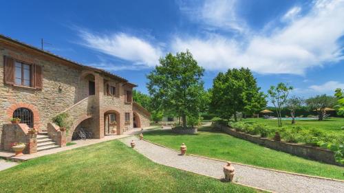 a stone house with a yard with a garden at Villa Augusto 10, Emma Villas in Piegaro