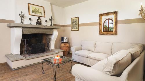 a living room with a couch and a fireplace at Villa Augusto 10, Emma Villas in Piegaro