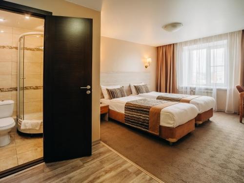 a hotel room with a bed and a bathroom at Aurora Hotel in Khabarovsk