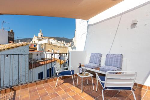 a balcony with two chairs and a table on a roof at Habitacions Bellaire Cadaqués in Cadaqués
