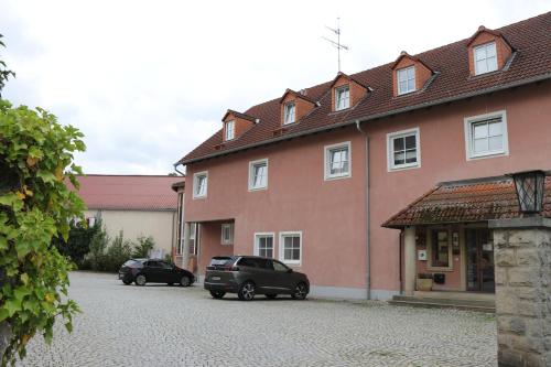 two cars parked in front of a building at Hotel Windfelder in Stegaurach