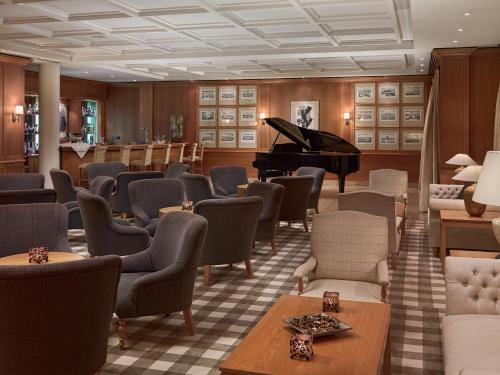 a waiting room with a piano and chairs at Hotel Las Madrigueras Golf Resort & Spa - Adults Only in Playa de las Americas