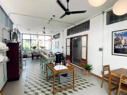 une salle à manger avec des tables et des chaises et un ventilateur de plafond dans l'établissement Baan Chiang Bed Lampang, à Ban Nam Thong