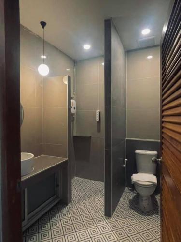 a bathroom with a toilet and a sink at Baan Chiang Bed Lampang in Ban Nam Thong