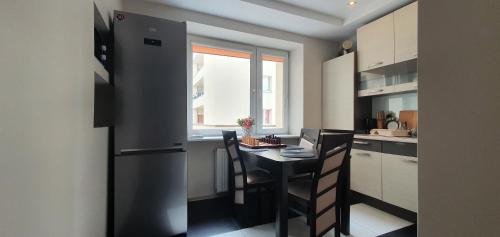 a kitchen with a black refrigerator and a table at Apartament Gdynia Kazart.Pl in Gdynia