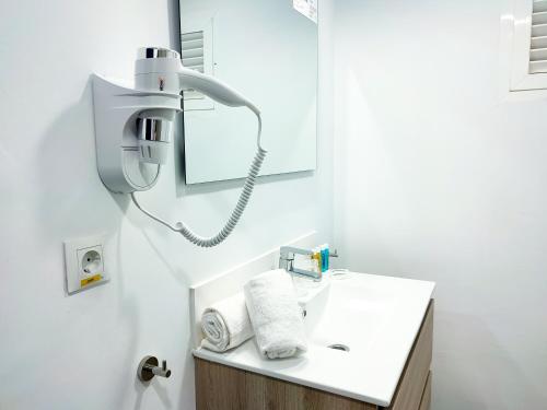 een badkamer met een witte wastafel en een spiegel bij Hotel Flats Friends Mar Blau in Benidorm