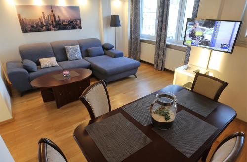 a living room with a table and a couch at Apartament MGM Karmelicka in Warsaw
