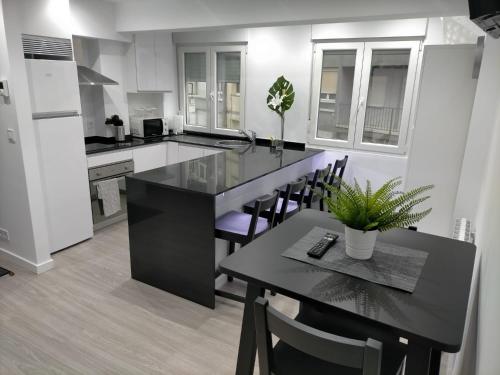 a kitchen with a black island in a kitchen with a table at Dávila HOME Beach in Santander